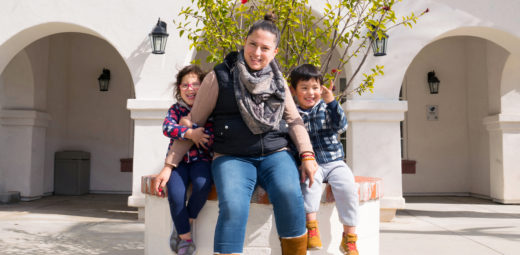 Angela with her two children sit outside of Casa San Juan