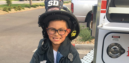 kid in firefighter helmet smiling